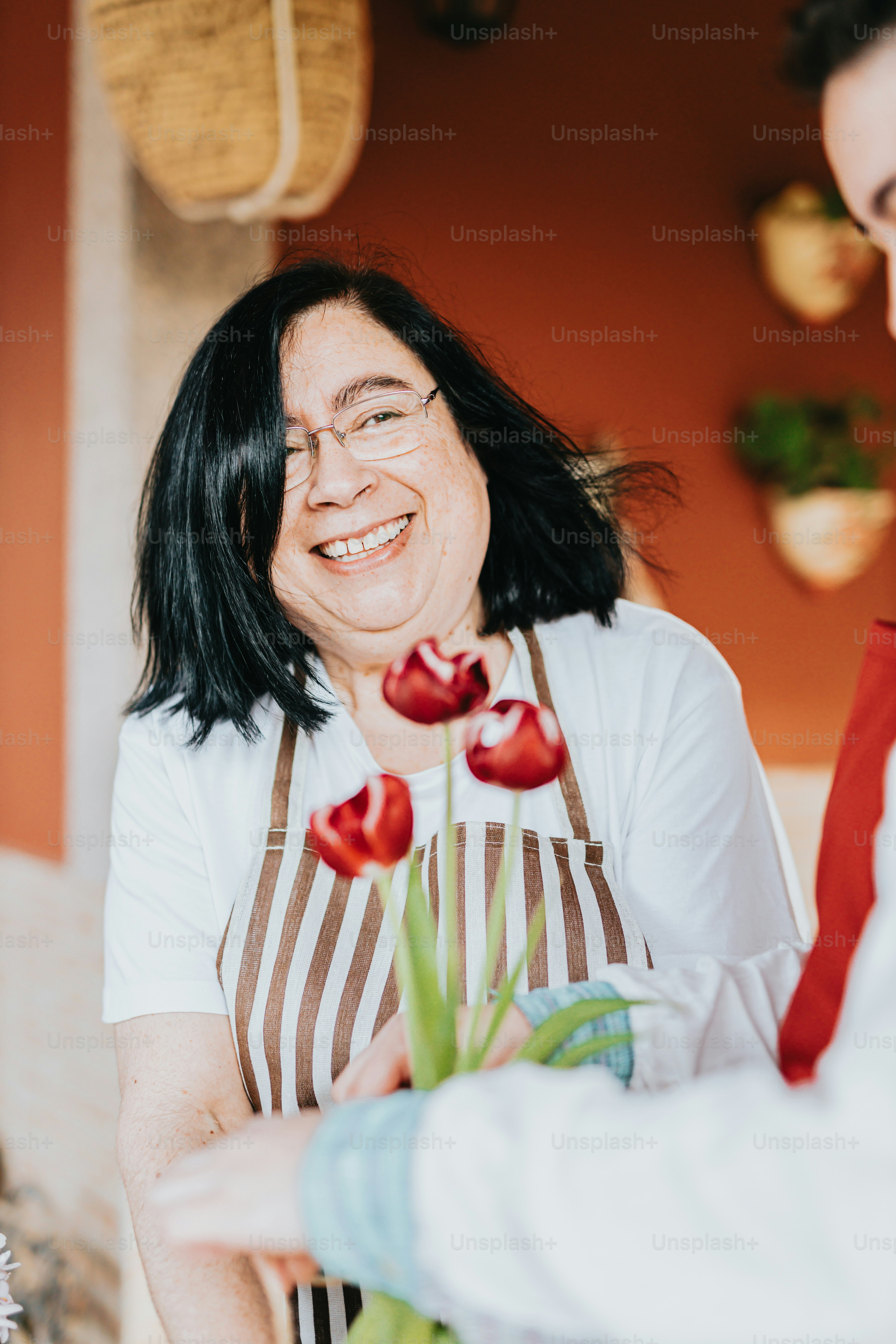 a woman holding a bouquet of red flowers