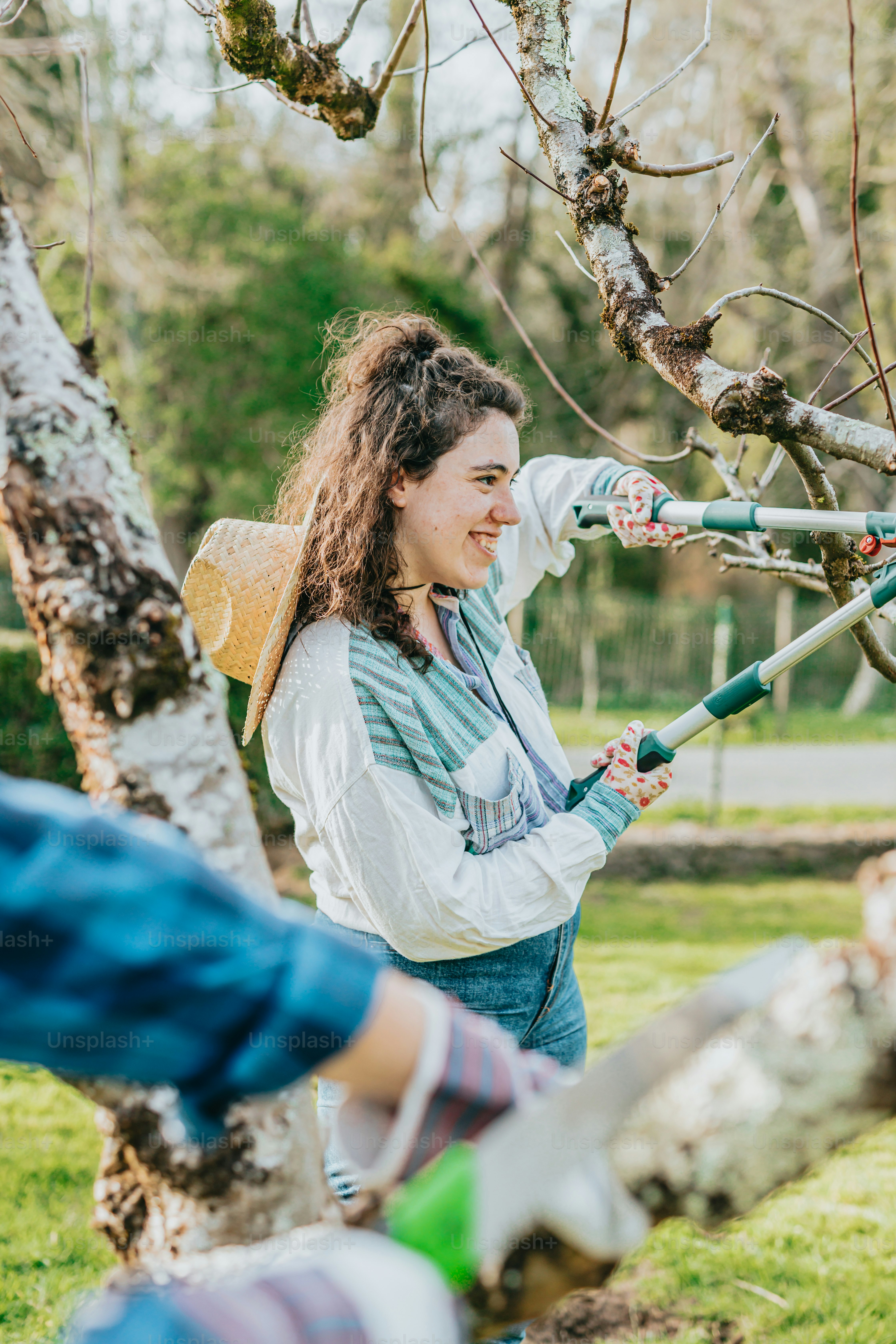 a woman holding a garden tool in a tree