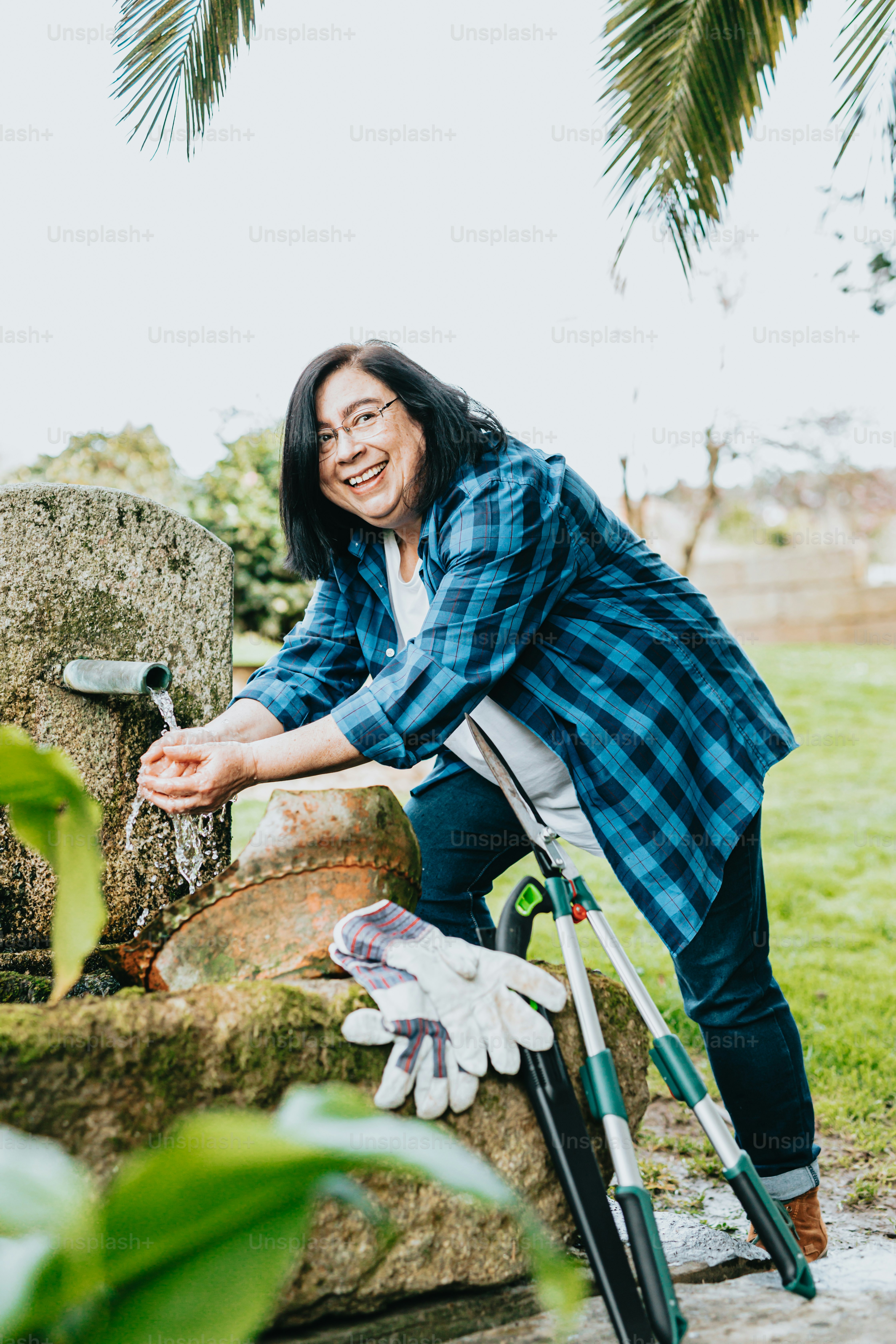 a woman in a plaid shirt is washing her hands