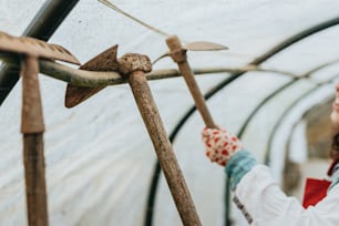 a woman in a white coat holding a wooden stick