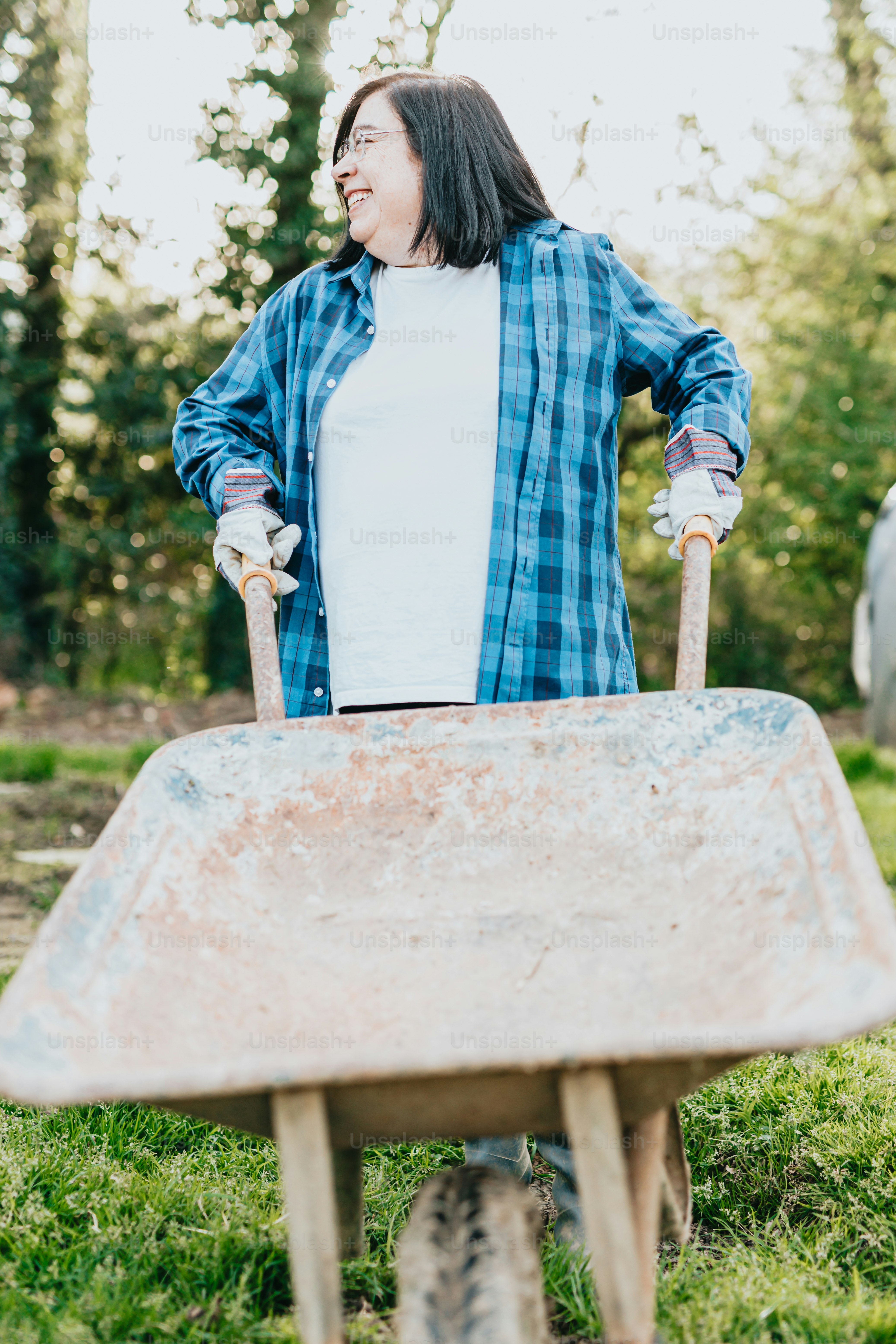 a woman standing next to a wheel barrow