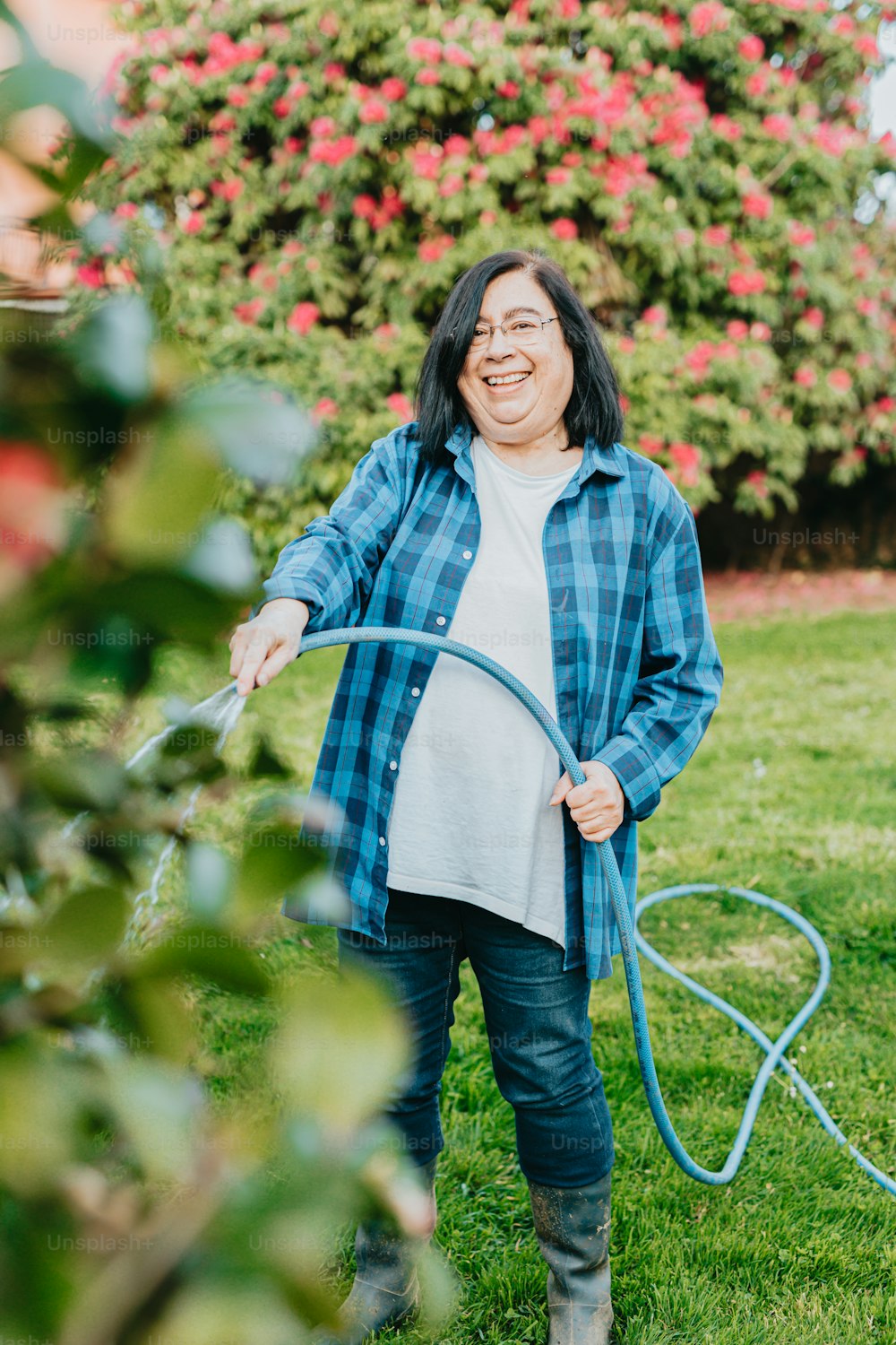 a woman holding a hose in her hands