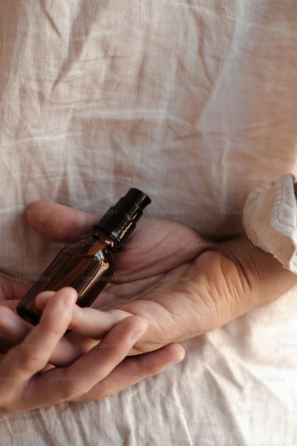 a person holding a small bottle in their hands