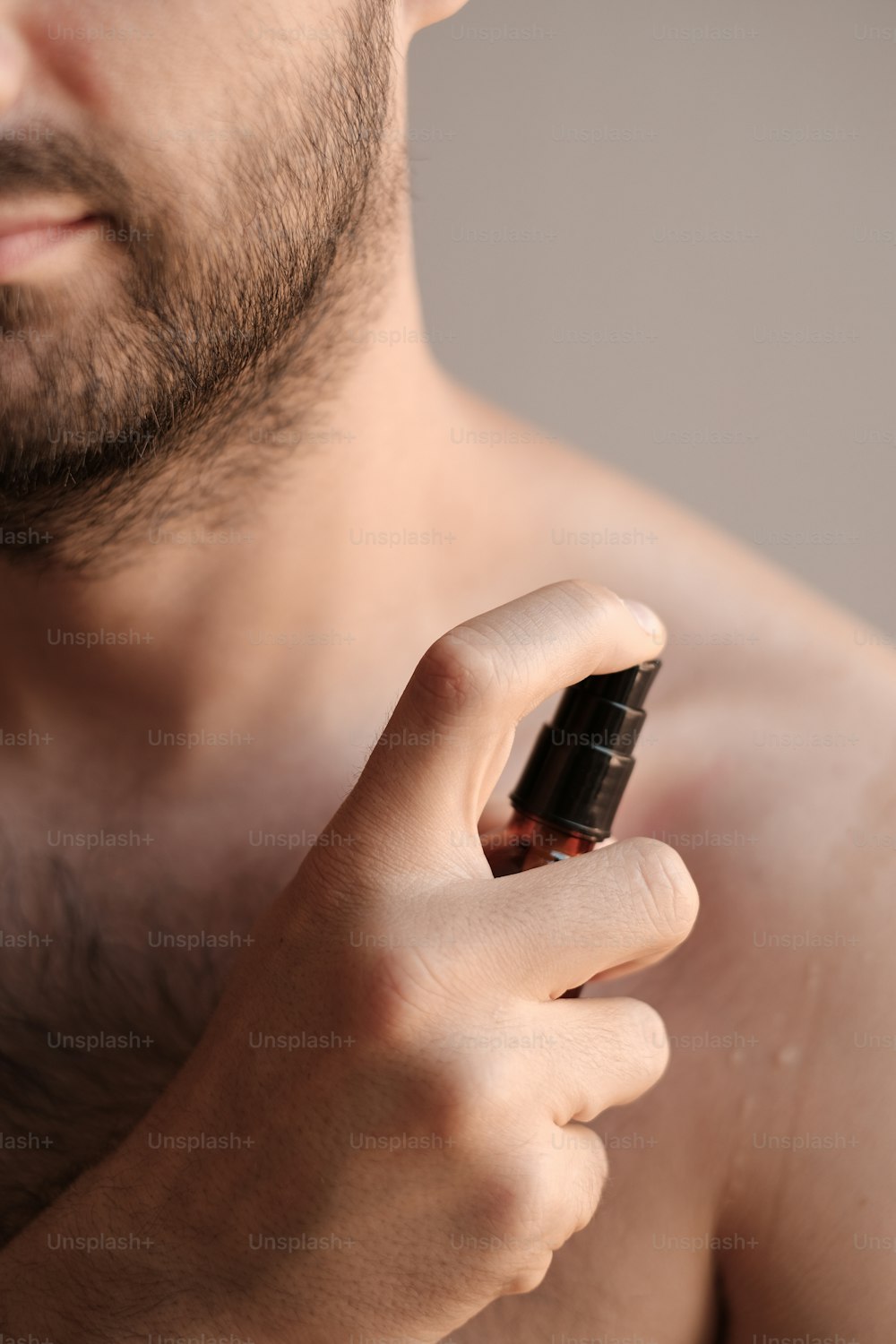 Un uomo a torso nudo con un cellulare in mano