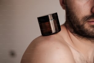um close up de um homem com um frasco no ombro