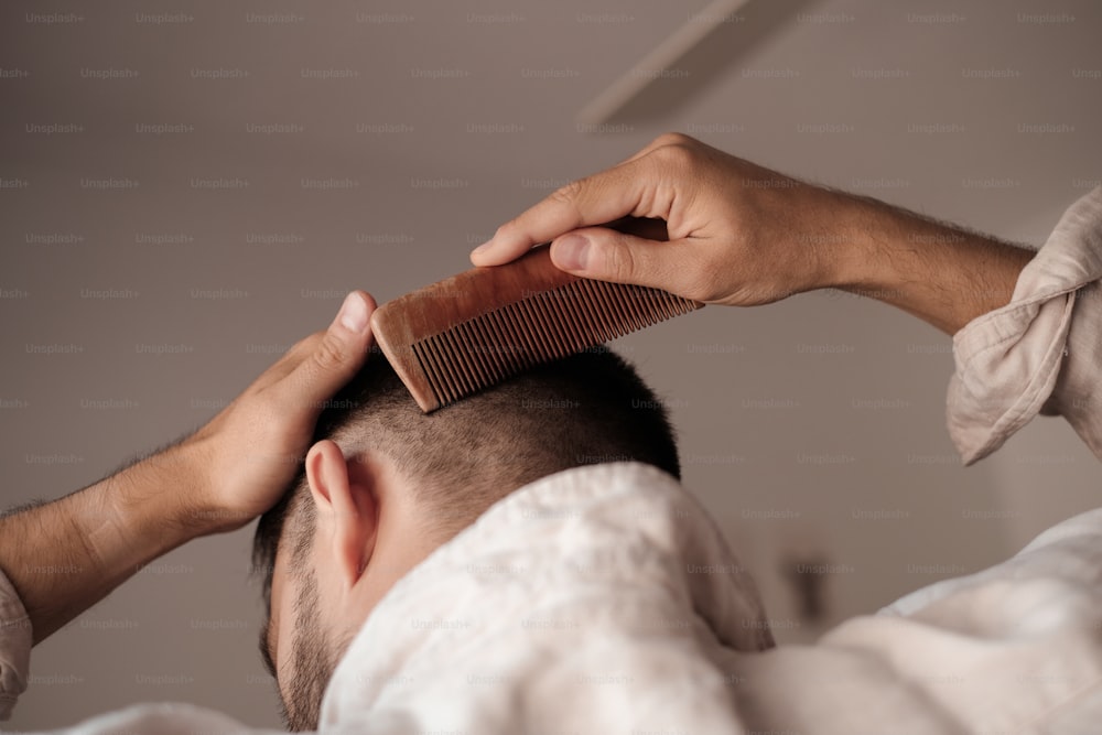 a man is combing his hair with a comb