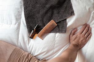 une personne allongée dans son lit avec un peigne et un peigne à la main