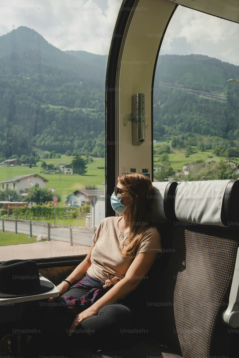 uma mulher sentada em um trem olhando pela janela