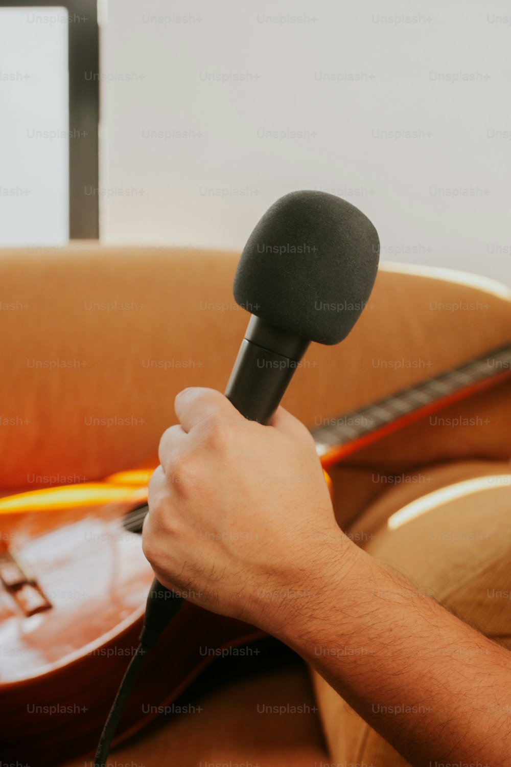una persona sosteniendo un micrófono y una guitarra