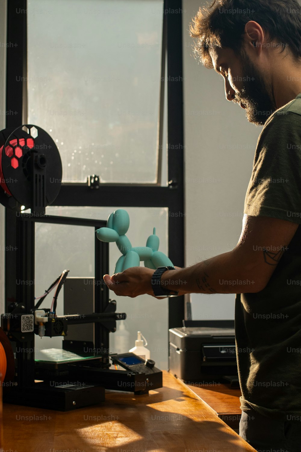 Un homme debout devant une imprimante 3D