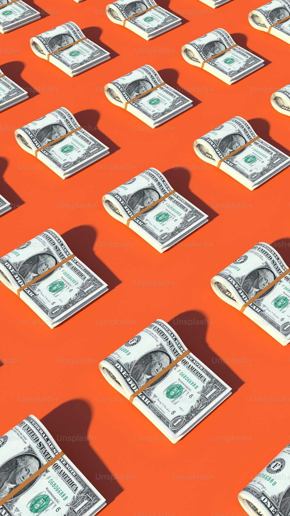 um monte de dinheiro sentado em cima de uma superfície laranja