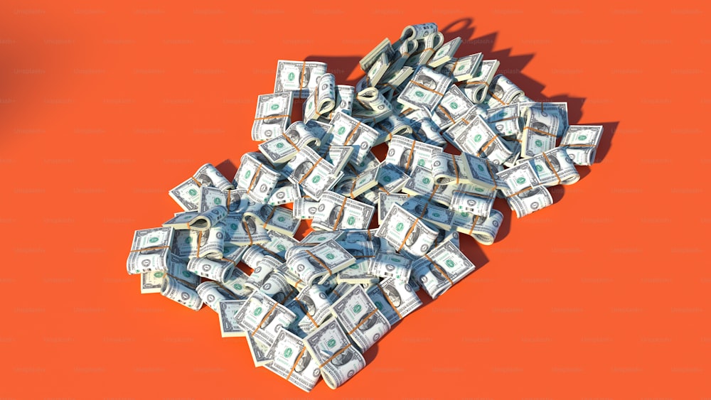 Un montón de dinero sentado encima de una superficie naranja