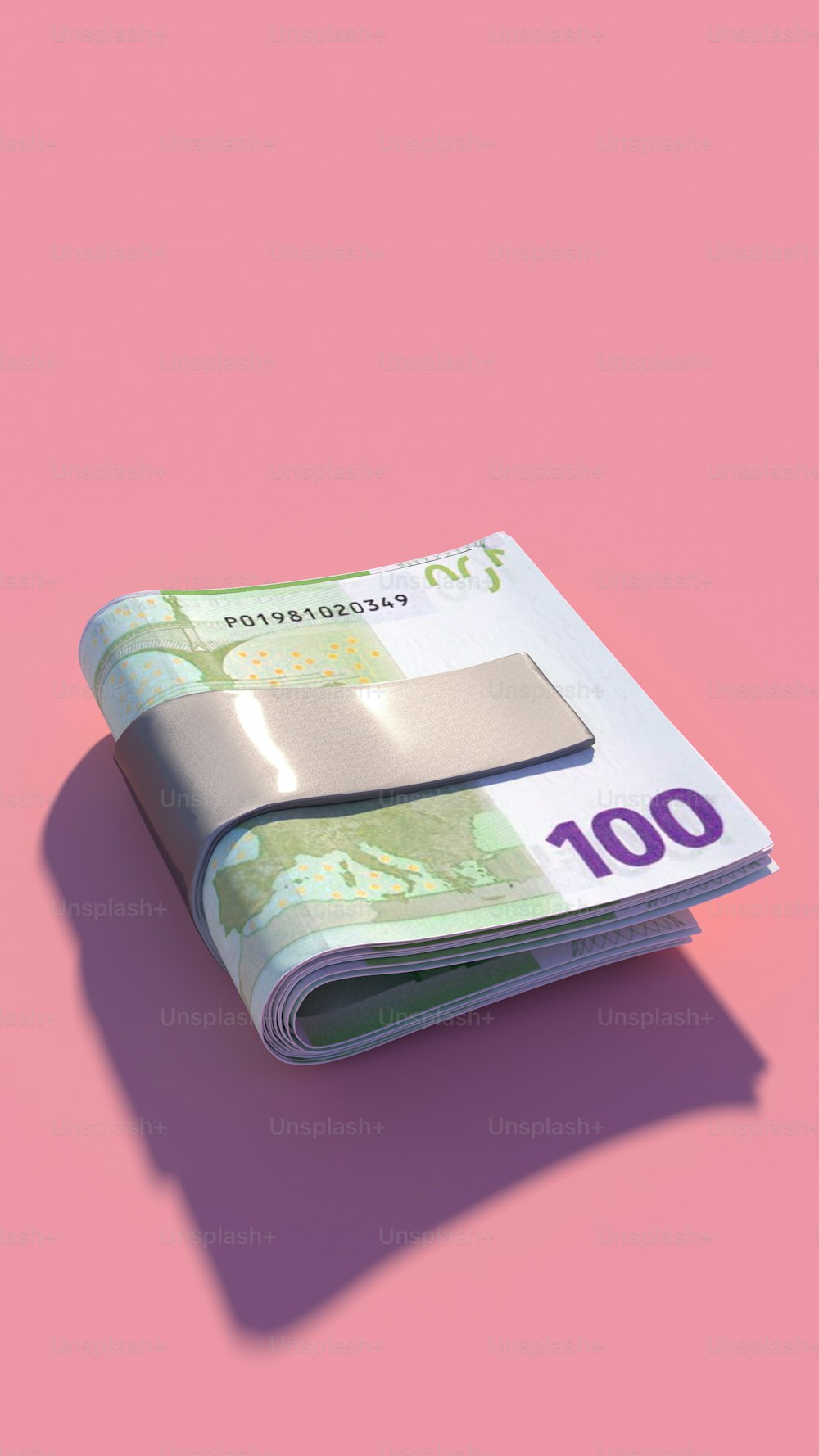 a stack of money sitting on top of a pink surface