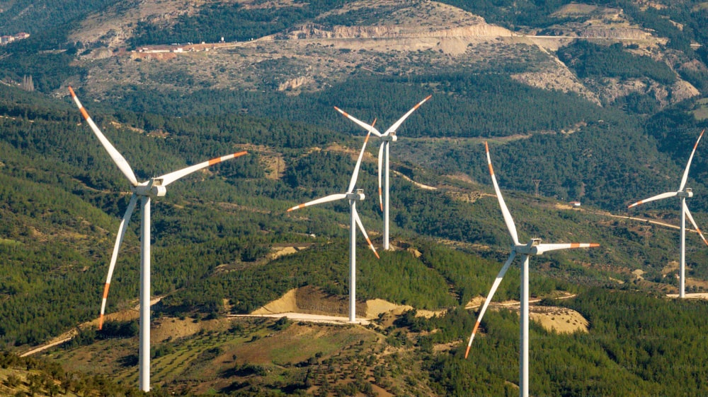 a group of wind turbines in a mountainous area