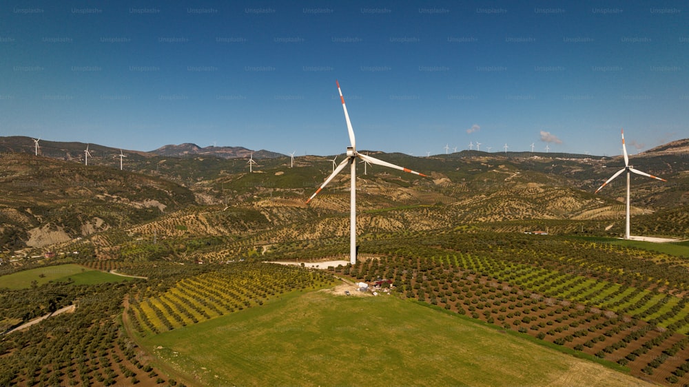 an aerial view of several wind turbines in a field