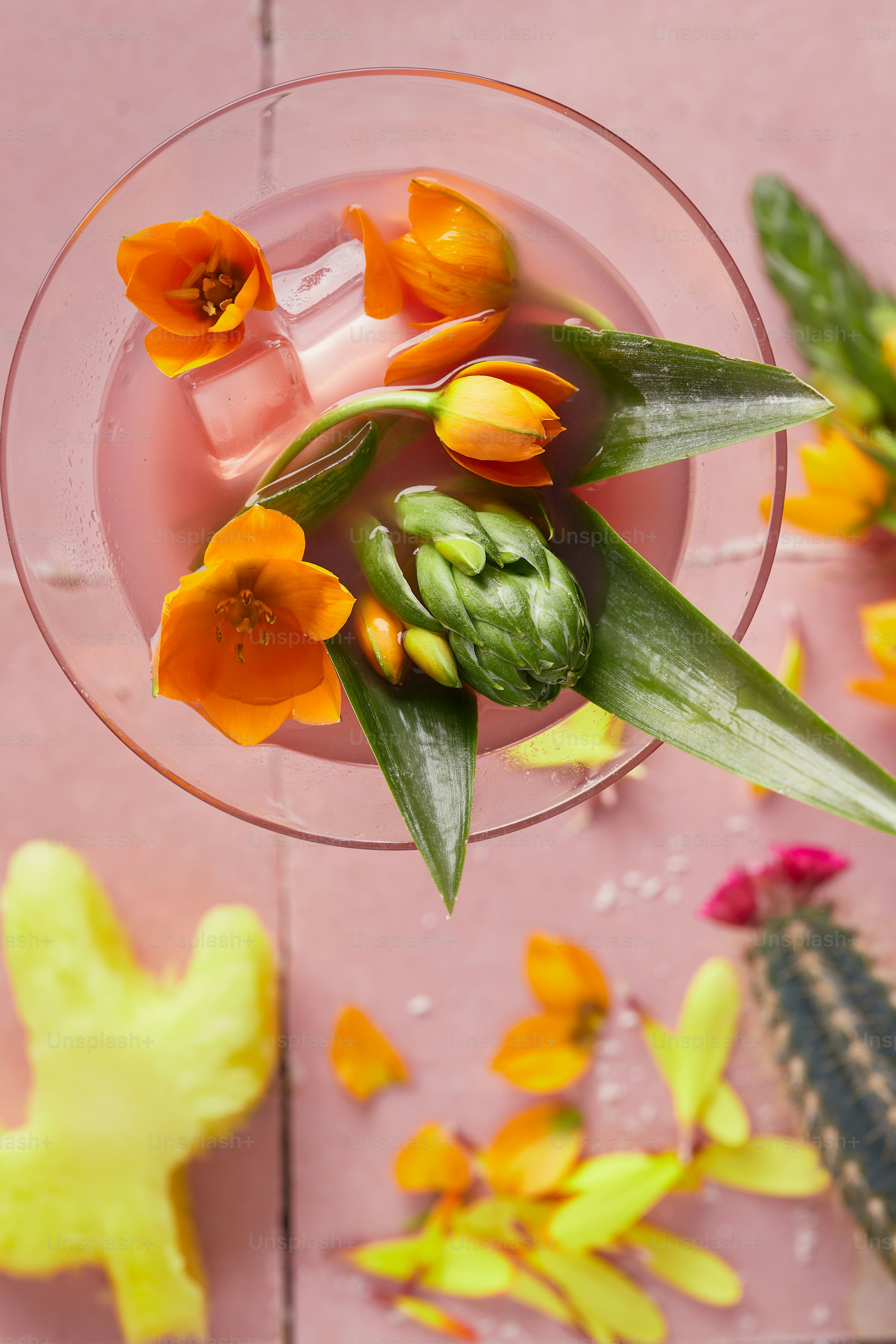 ein Glas mit ein paar Blumen drin auf einem Tisch