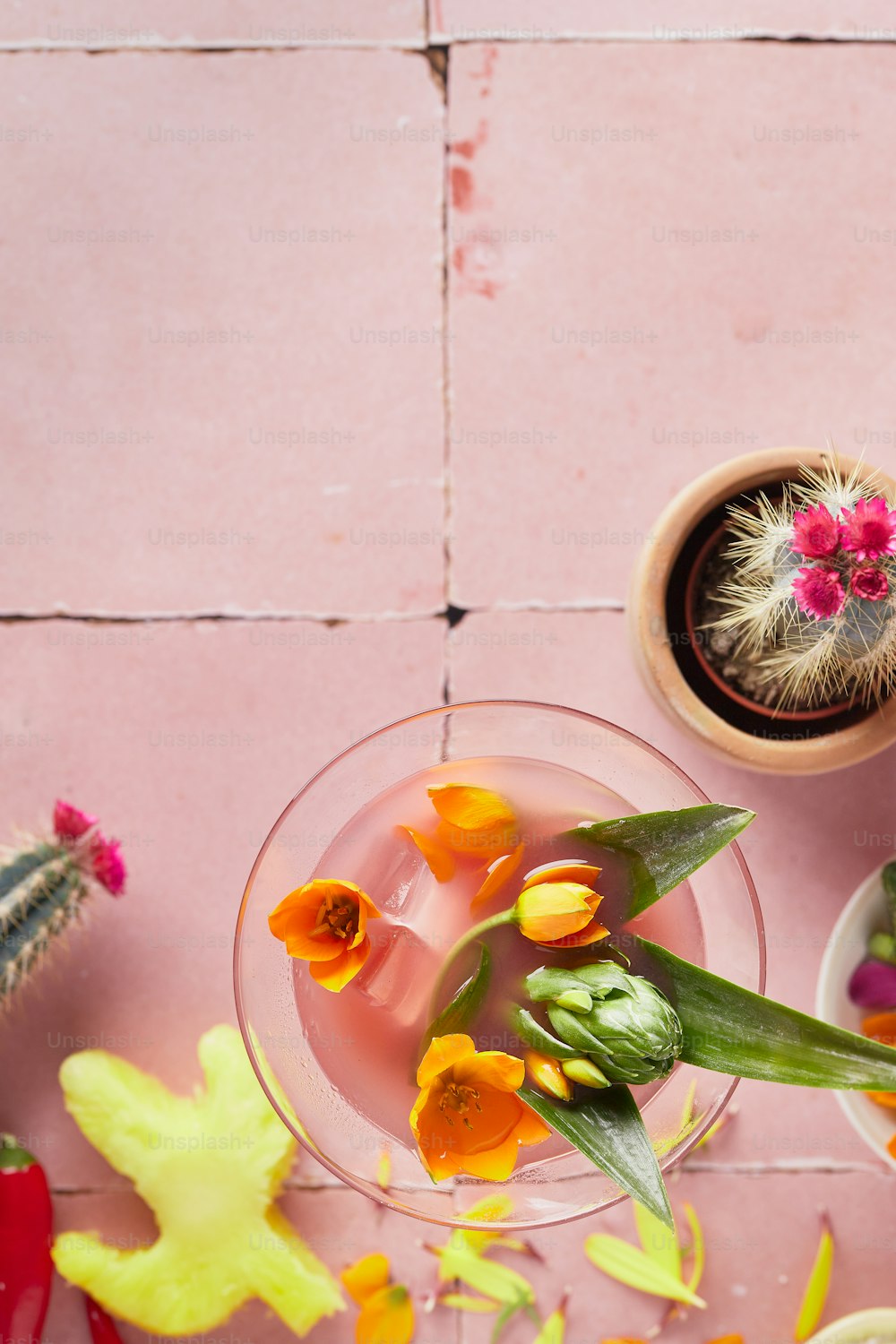 a pink table topped with a glass filled with flowers