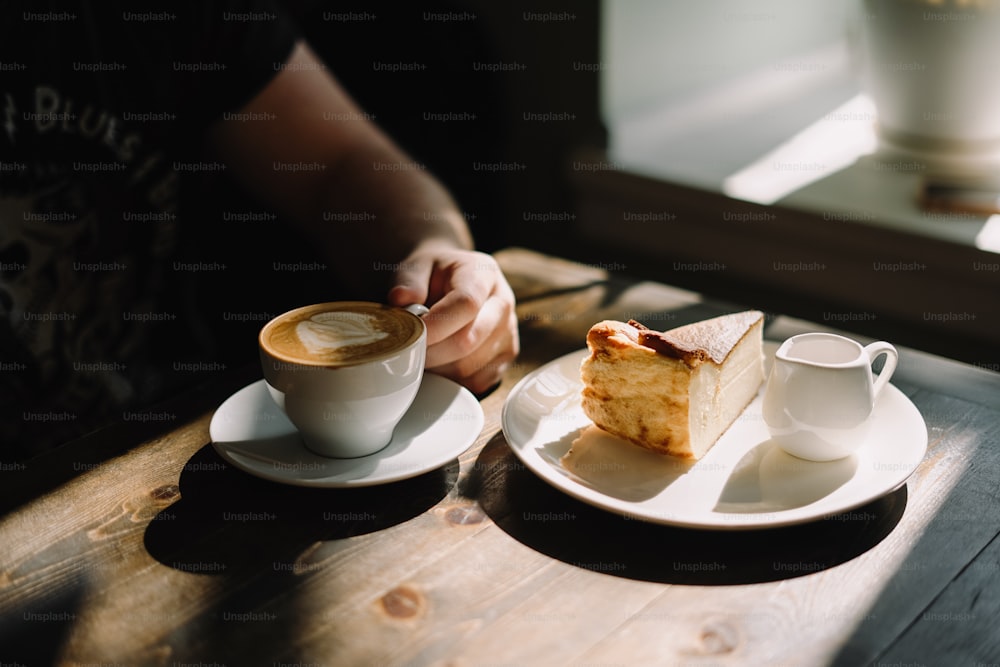 um pedaço de bolo e uma xícara de café em uma mesa