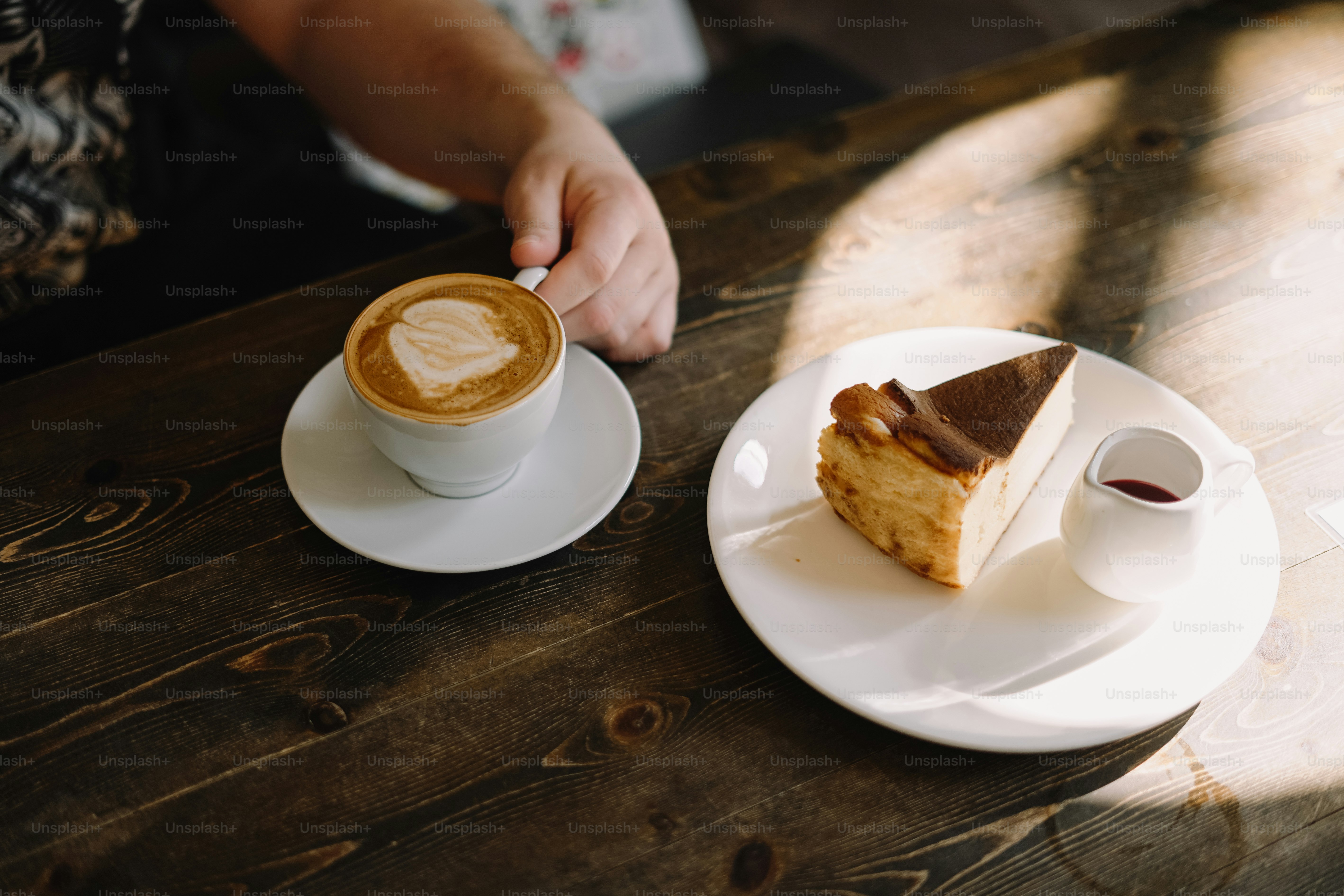 ein Stück Kuchen auf dem Teller neben einer Tasse Kaffee