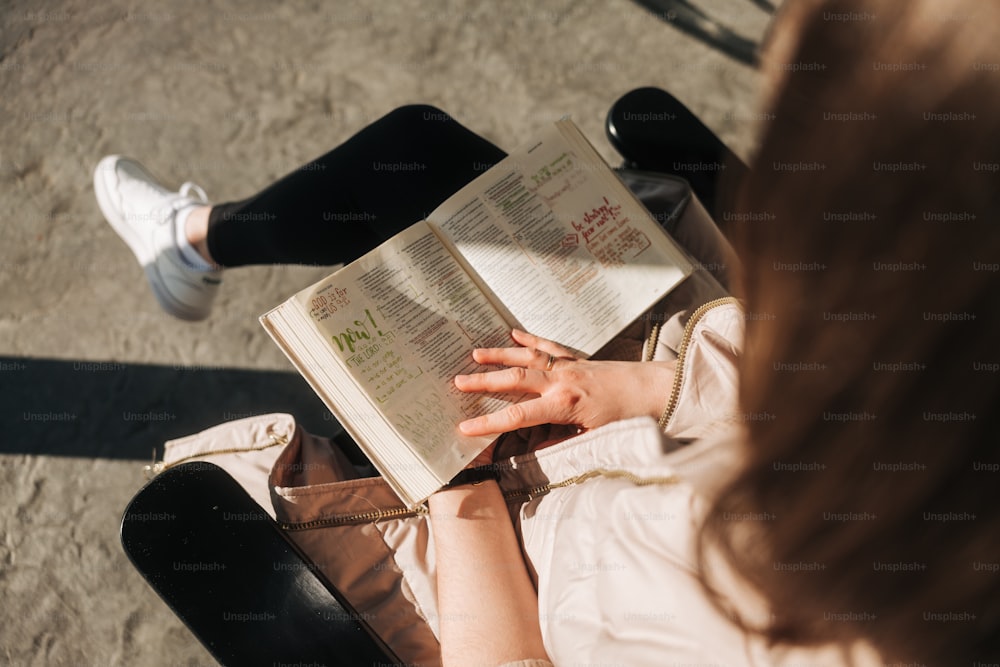 a woman sitting on a chair reading a book