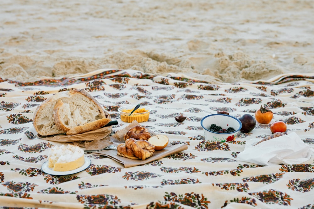 uma mesa coberta com um prato de comida em cima de um cobertor
