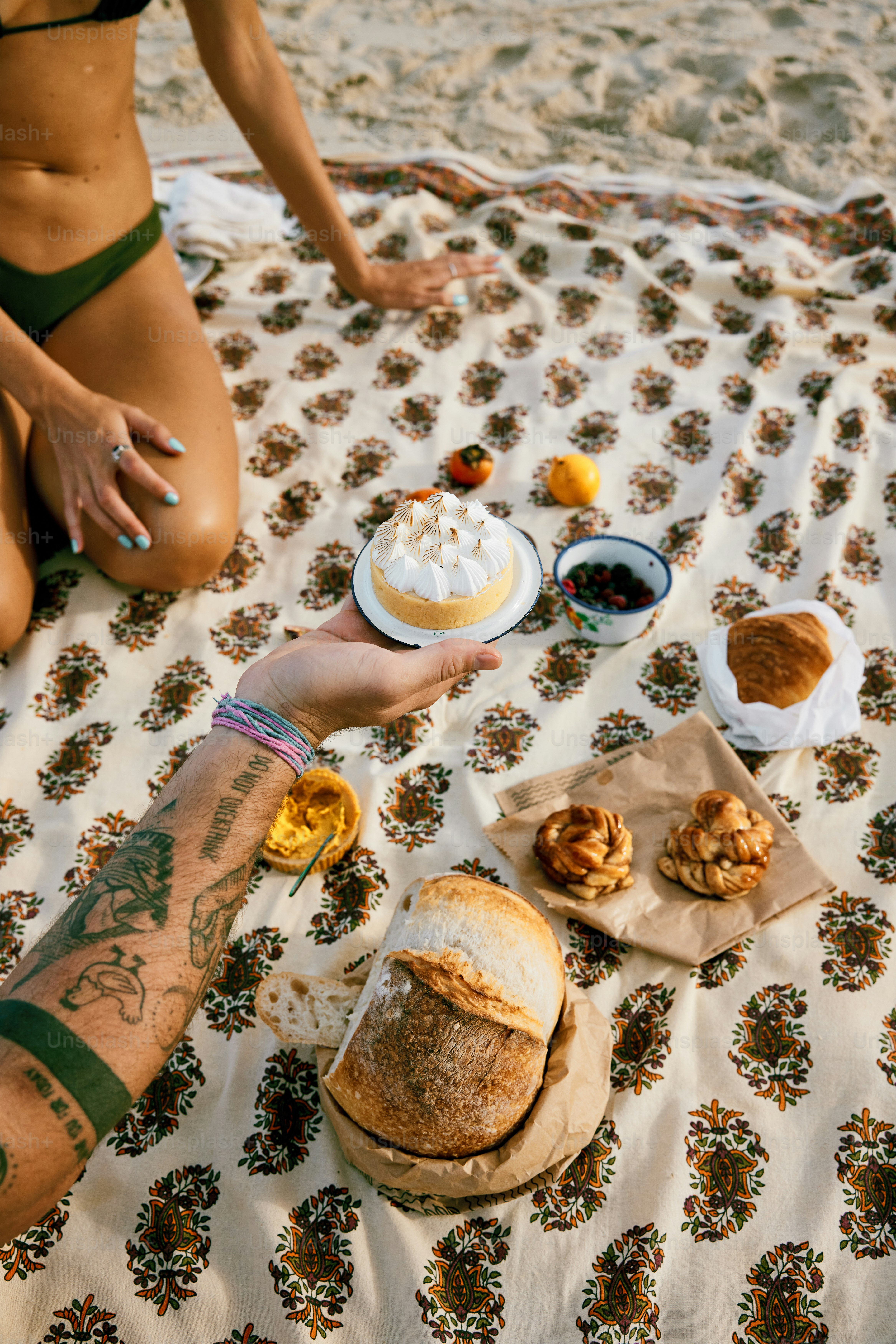 a person sitting on a blanket with food on it