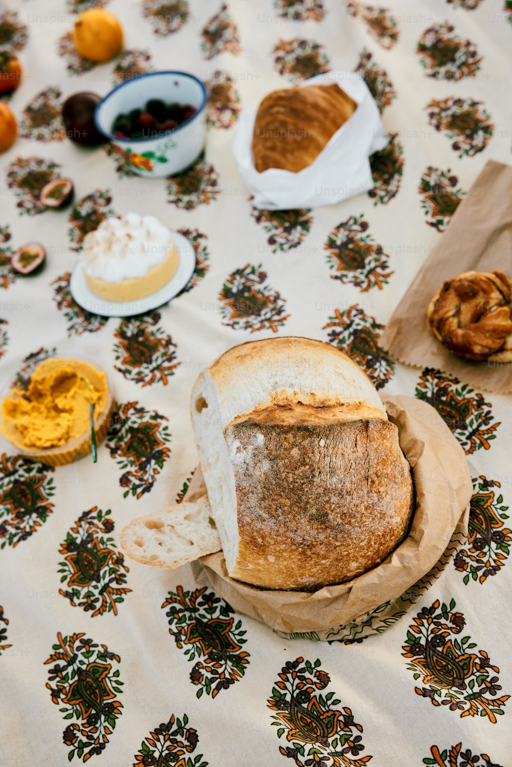 a table topped with bread and pastries on top of a table cloth