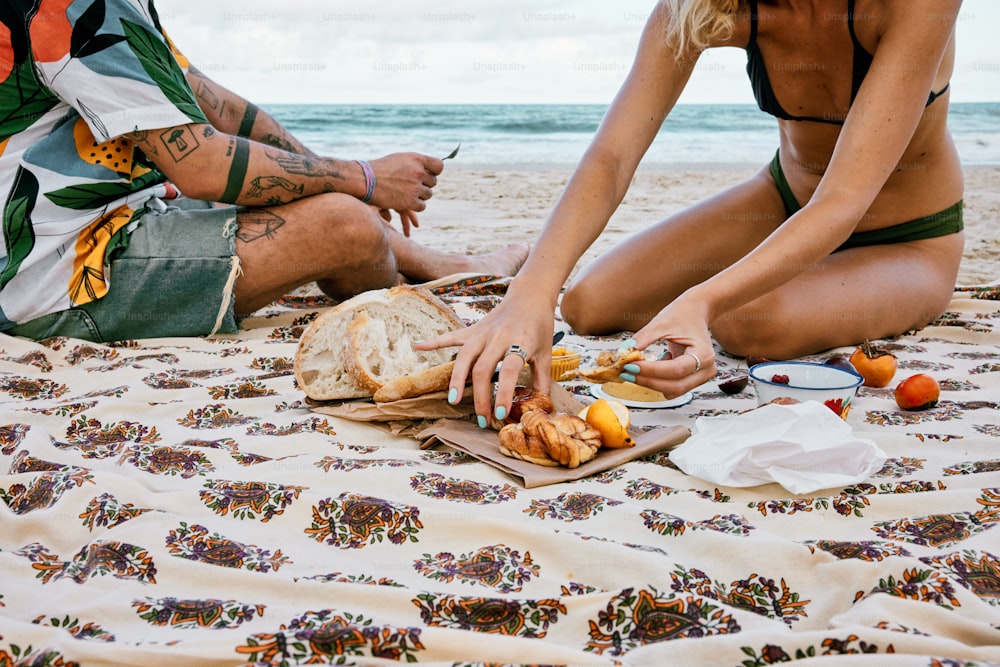 a couple of people sitting on top of a beach