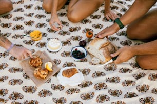 a group of people sitting on top of a bed eating food