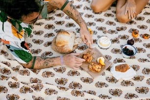 a person sitting on a bed with a plate of food