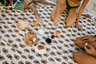 Eine Gruppe von Menschen, die am Strand sitzen und Essen essen