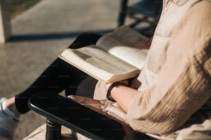 a woman sitting in a chair reading a book