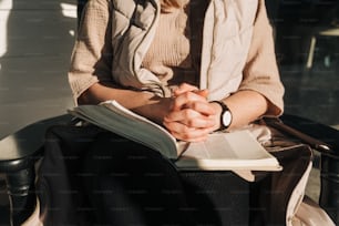 a woman sitting in a chair holding a book