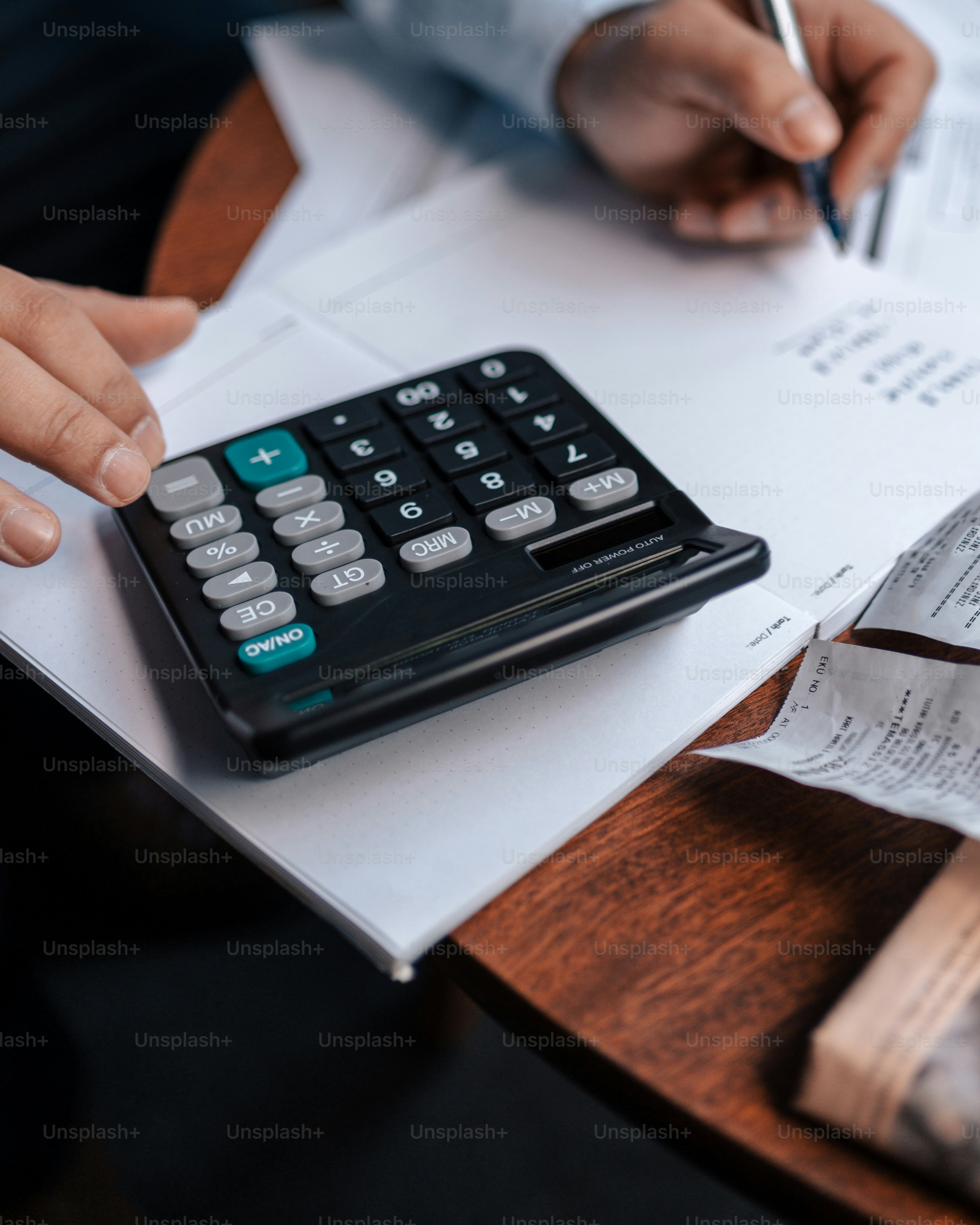 a person sitting at a table with a calculator