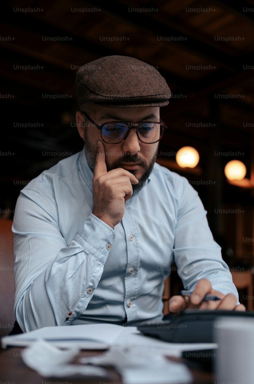 um homem sentado em uma mesa olhando para um tablet