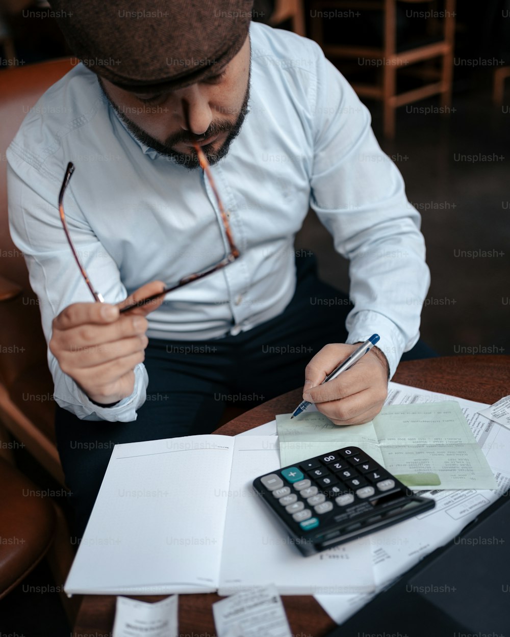 a man sitting at a table with a calculator and pen