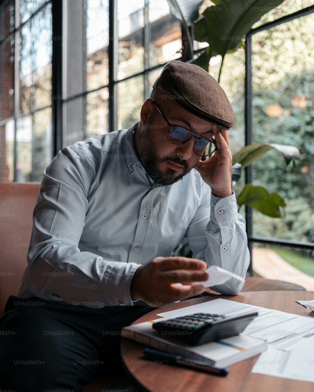 um homem sentado em uma mesa com uma calculadora