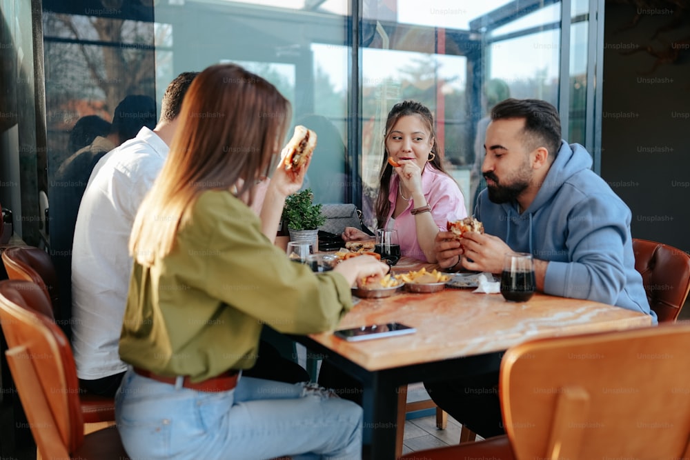 a group of people sitting around a table eating food