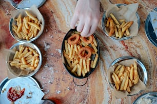a person reaching into a bowl of french fries
