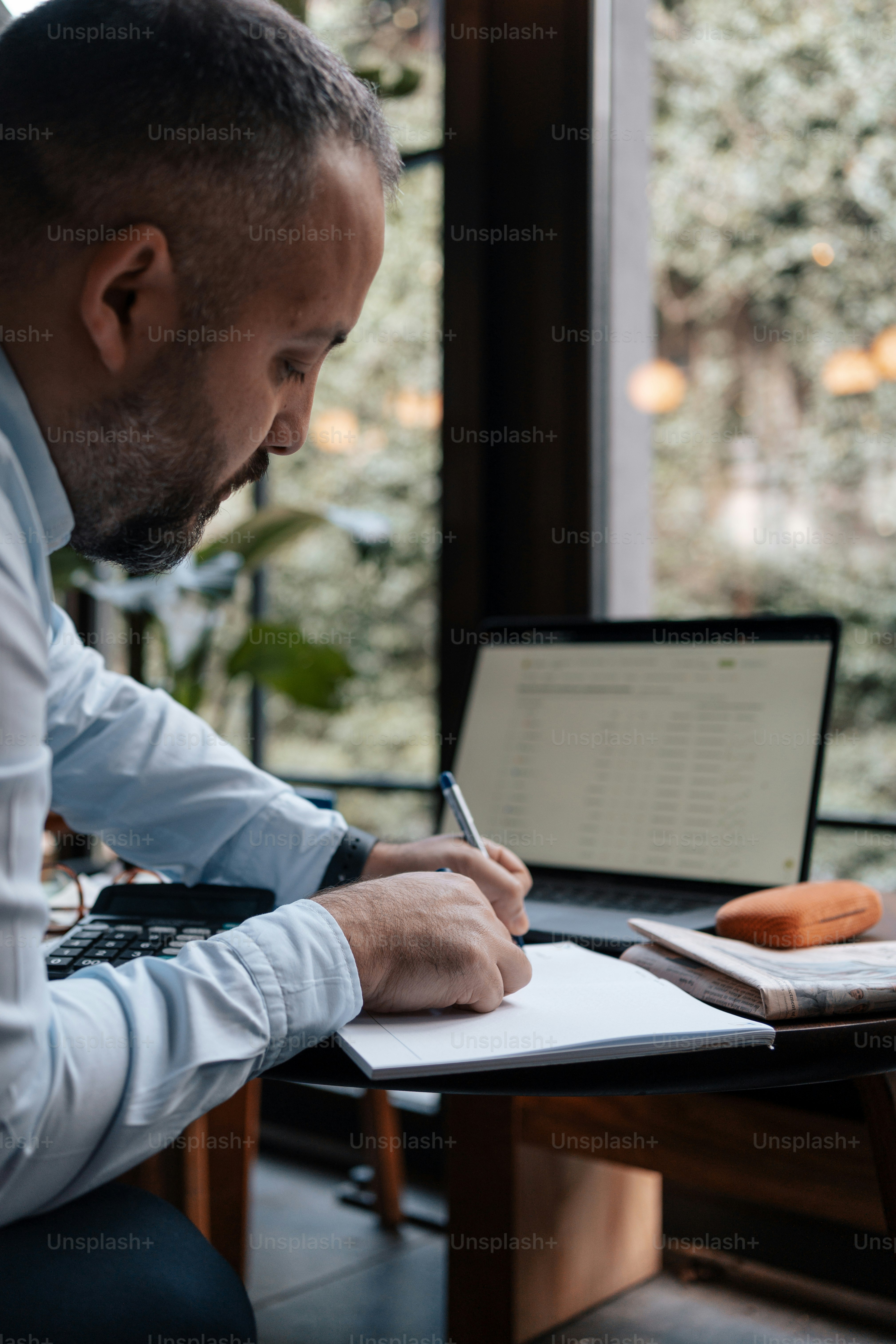 a man sitting at a desk writing on a piece of paper