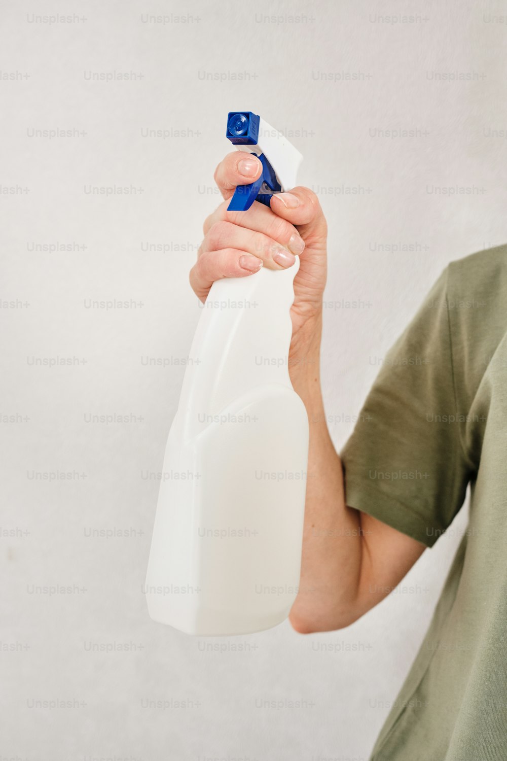 a person holding a plastic bottle with a blue handle