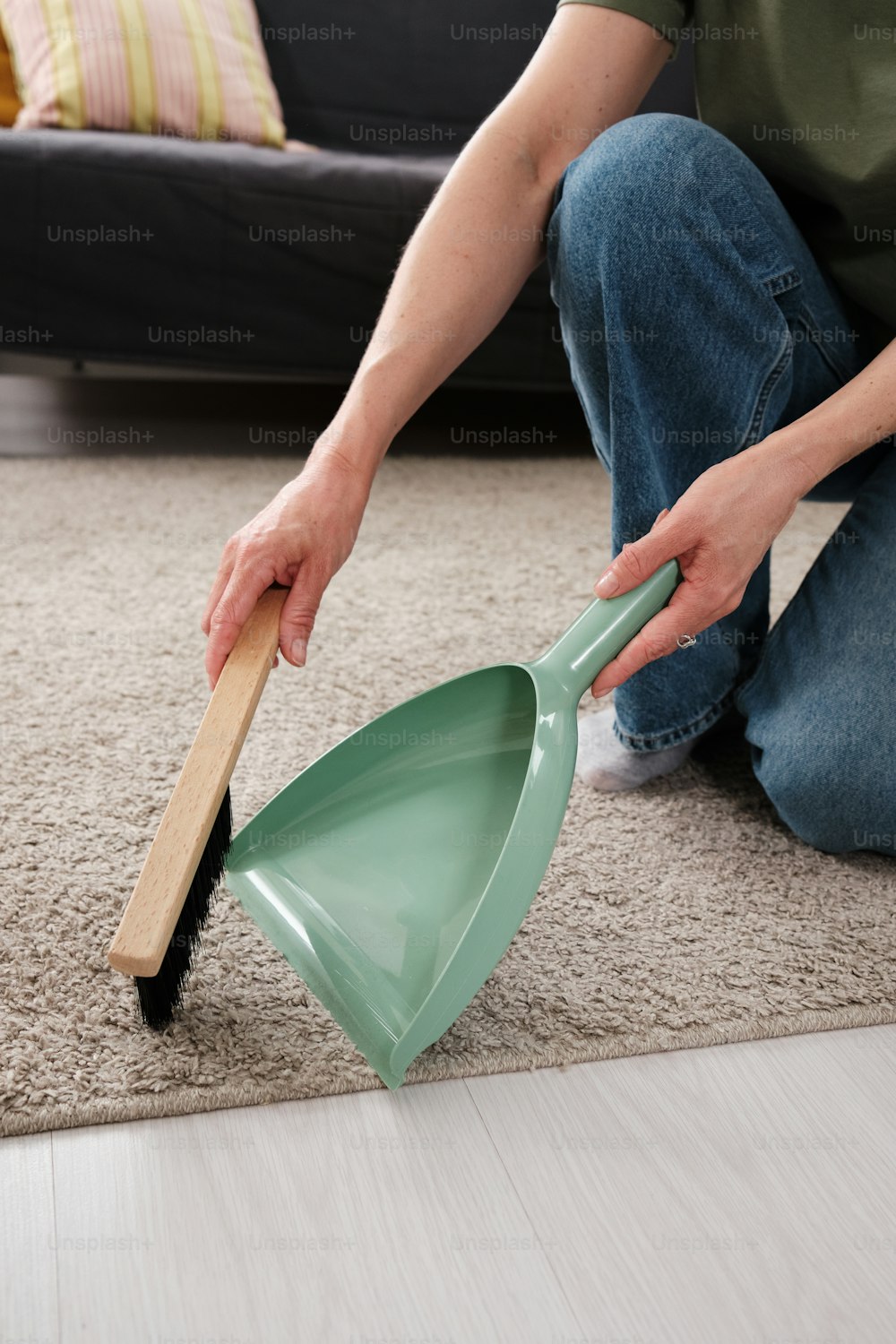 a person kneeling on the floor with a shovel