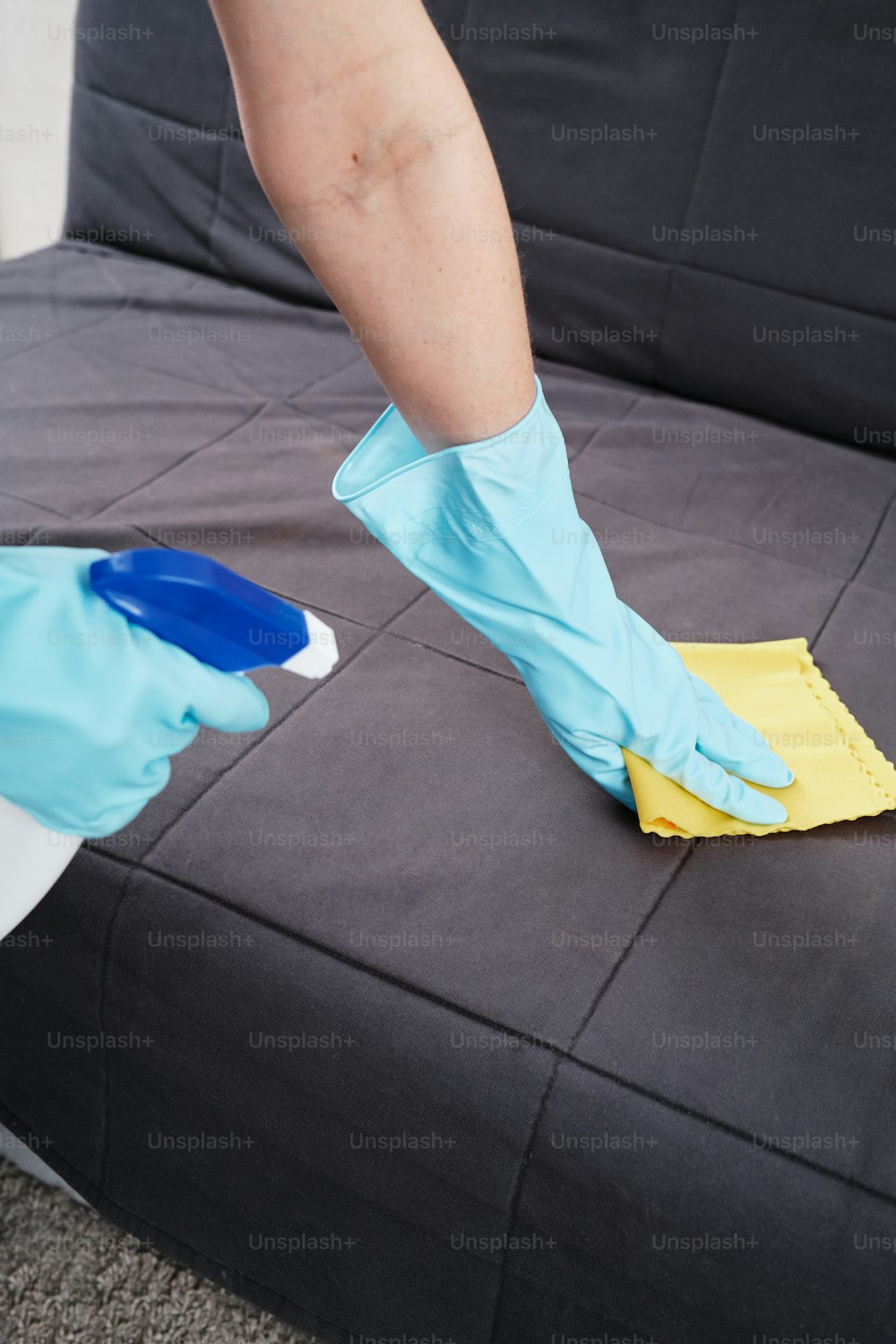 a person cleaning a couch with a sponge