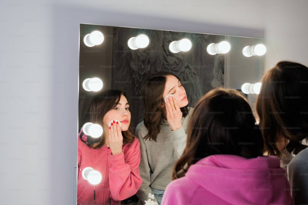 Una donna in piedi davanti a uno specchio che si lava i denti