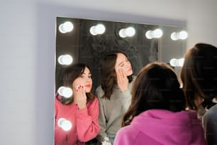 a woman standing in front of a mirror brushing her teeth