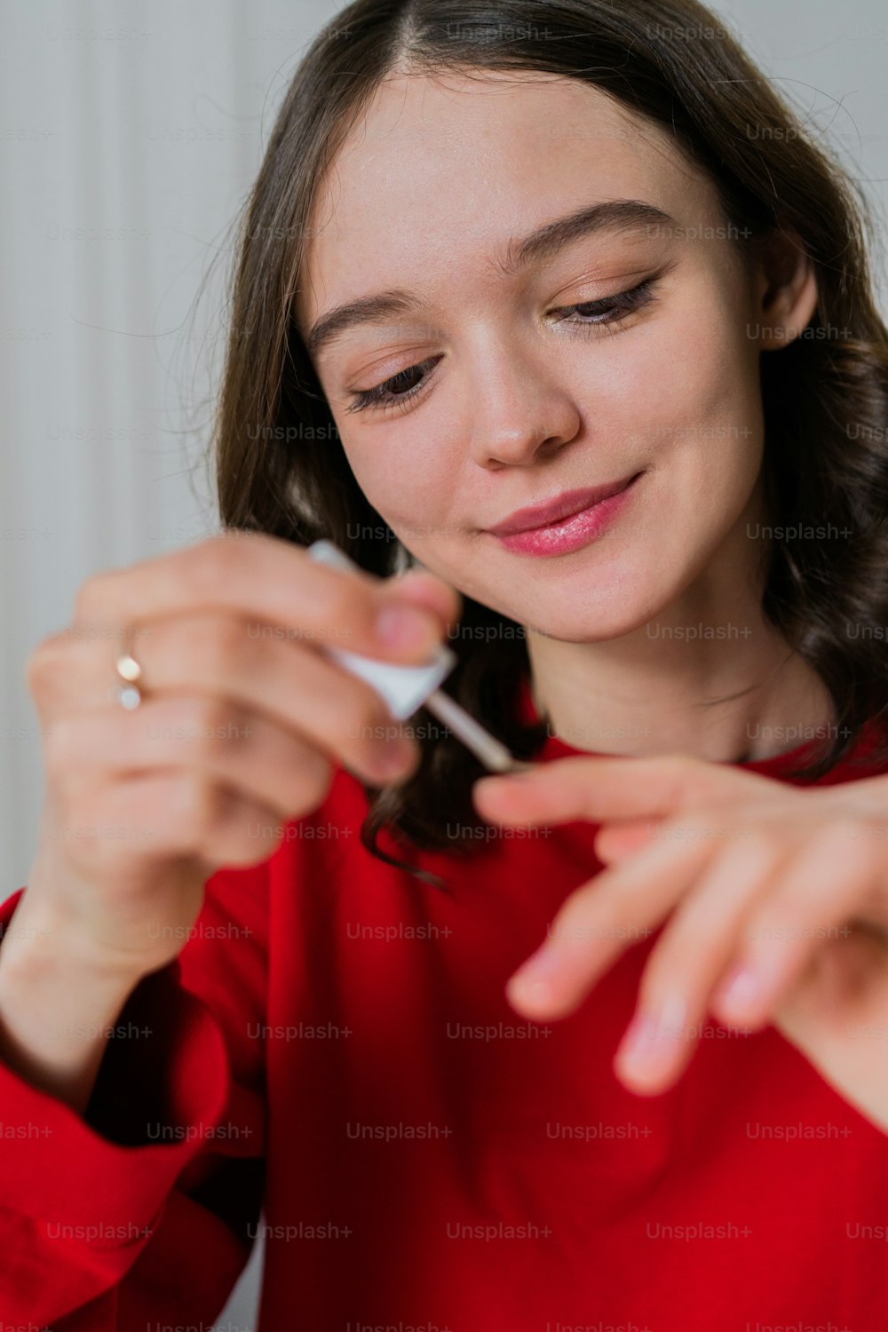 a woman in a red shirt is holding a toothbrush