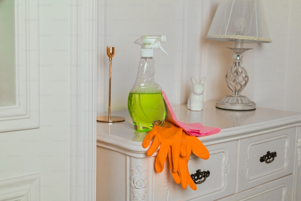 a pair of orange gloves sitting on top of a white dresser