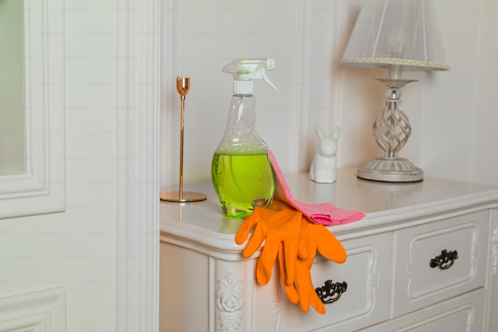 a pair of orange gloves sitting on top of a white dresser