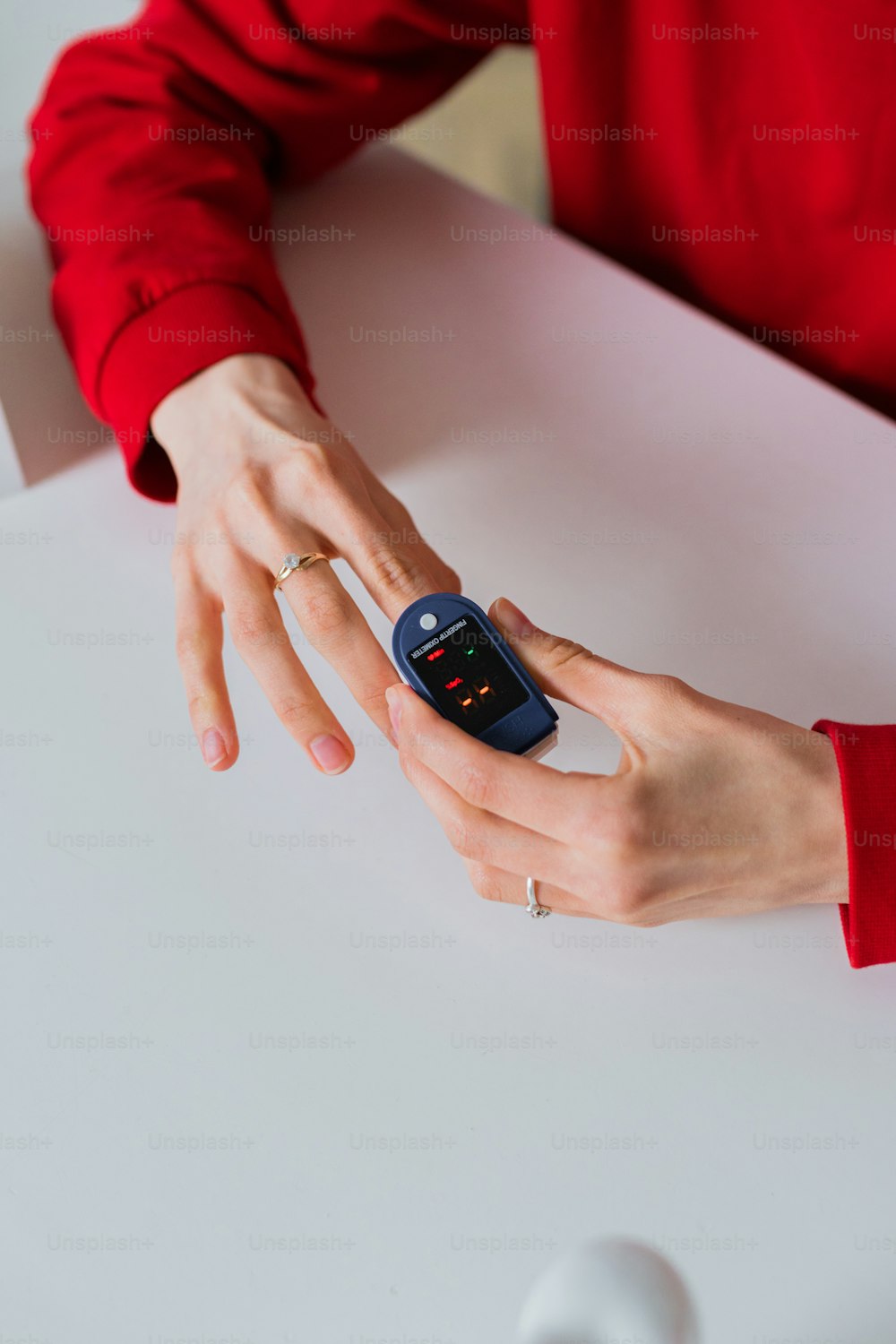 Eine Frau im roten Hemd hält ein Handy in der Hand