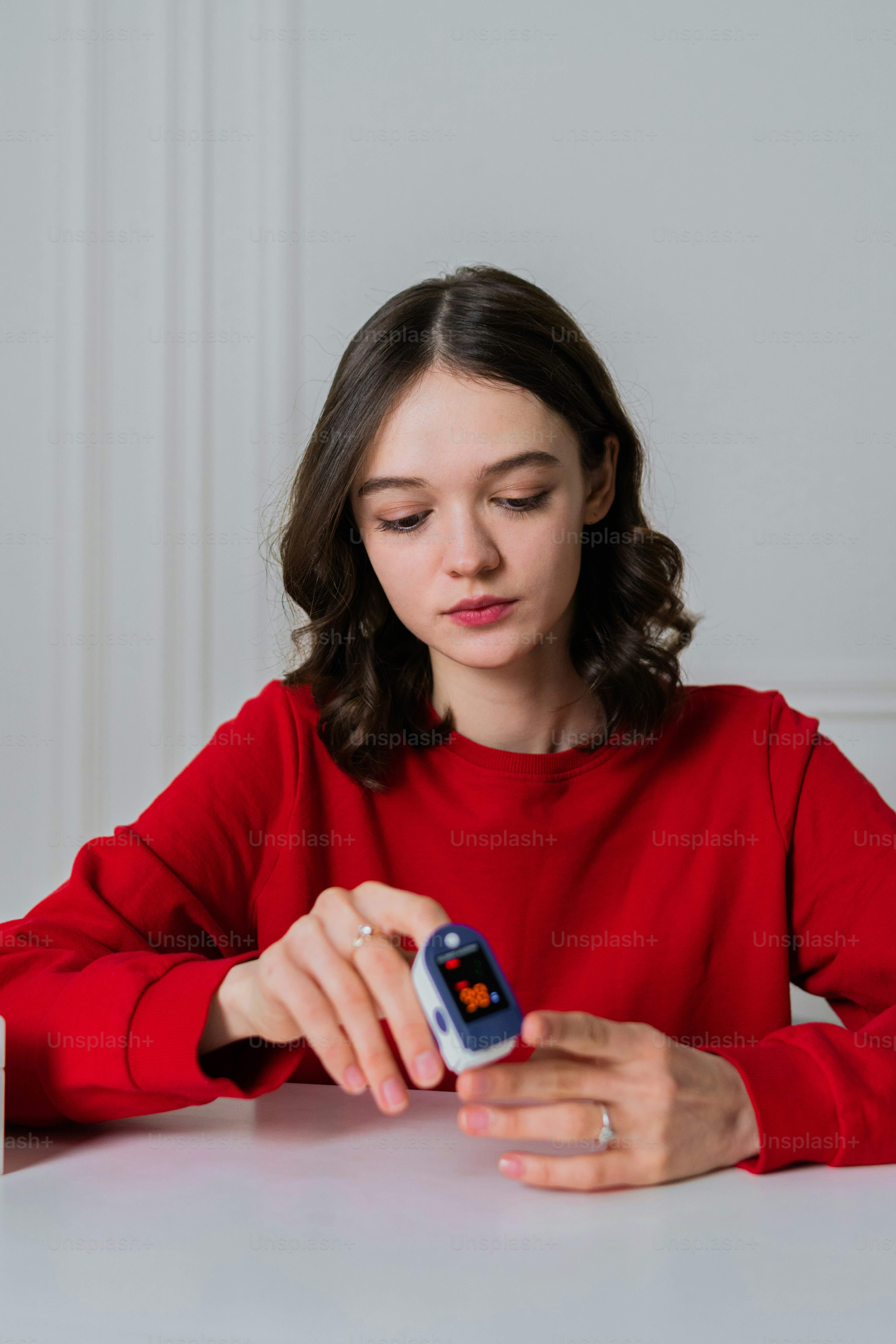 a woman sitting at a table looking at a cell phone